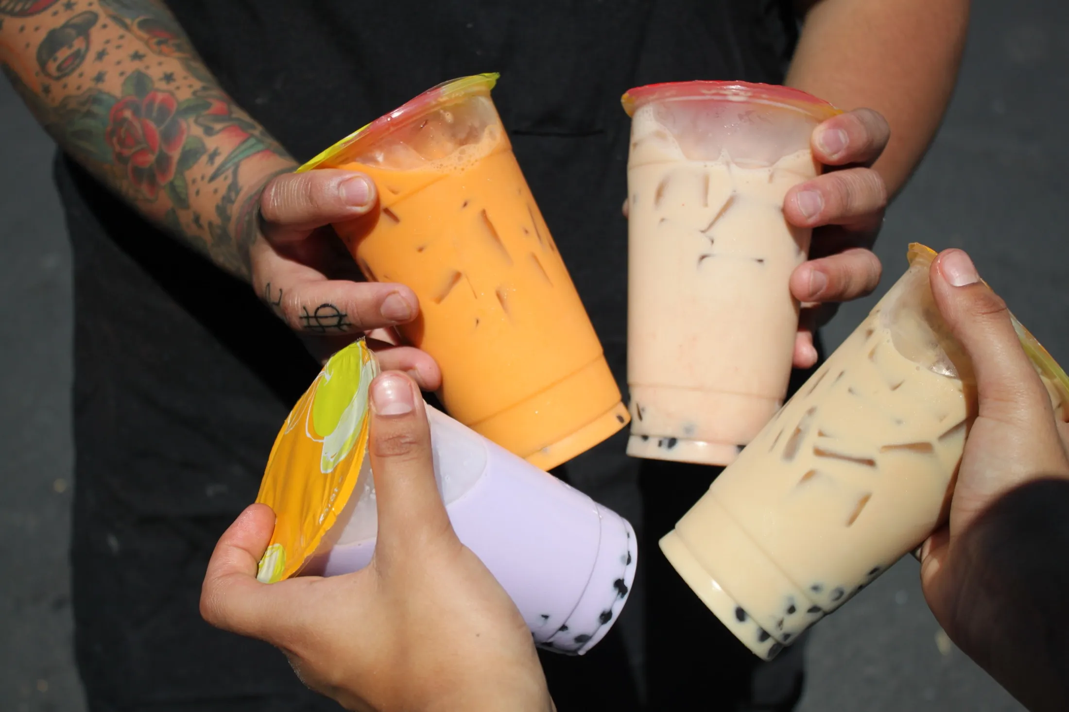 A fan of colorful Peace Love & Boba drinks
